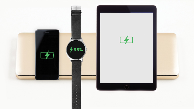 A smart phone, a smart watch and a tablet on a charging pad
